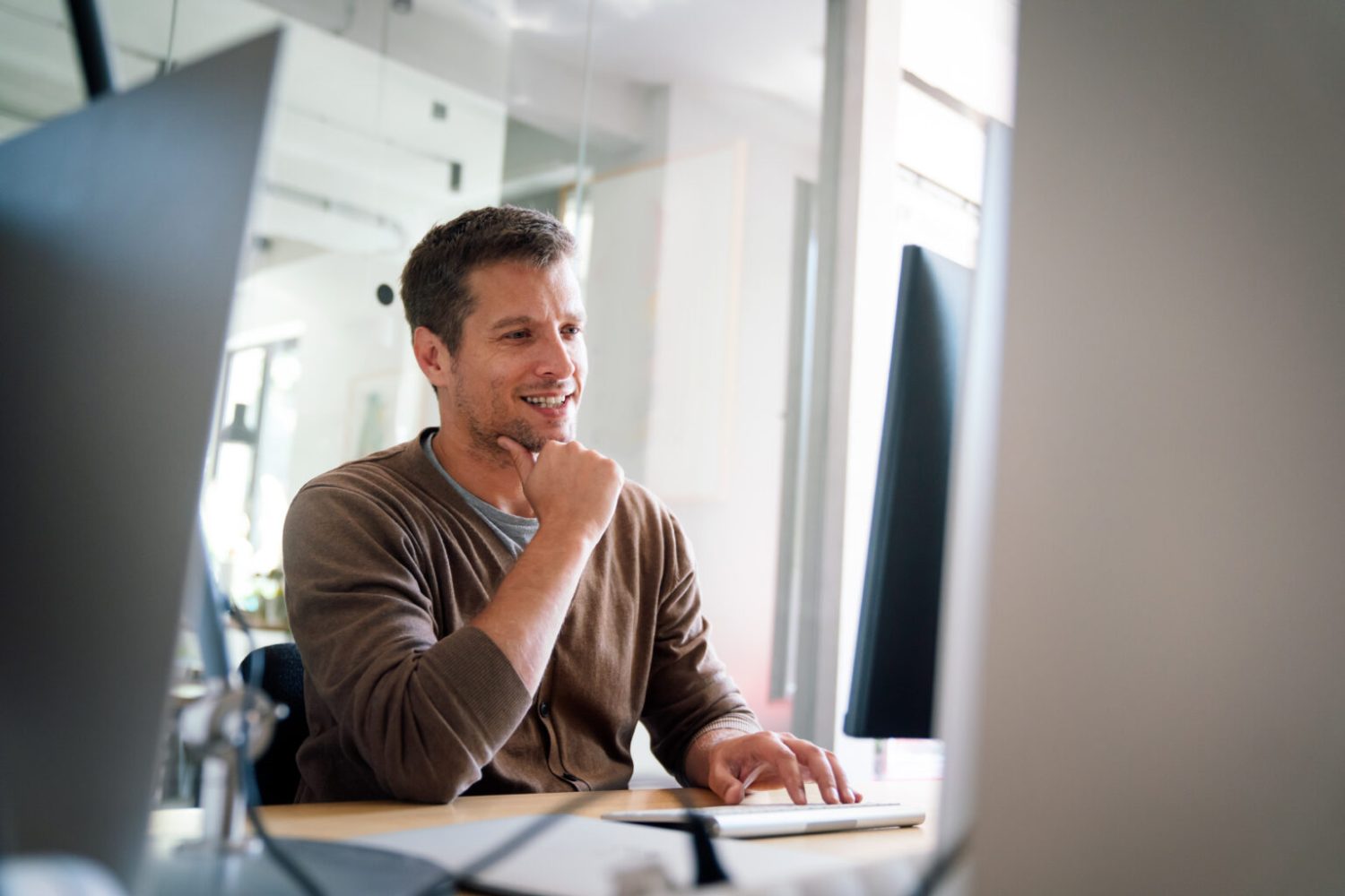 Programmer, web developer, designer working at an office, comparing mobile and desktop website versions. Business people concept.