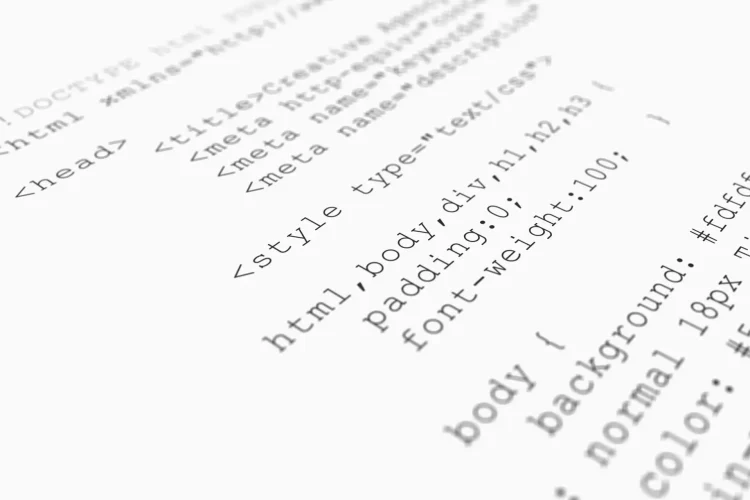 Website HTML code browser view printed on white paper, closeup view.