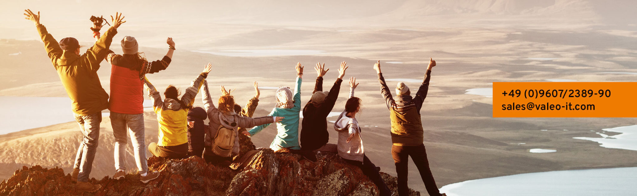 Personengruppe am Hügel mit Hände in der Luft
